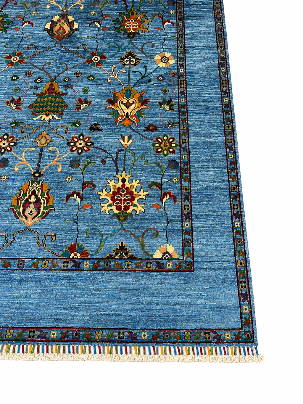 Angled view of the corner of a Chobi Sultani hand-knotted Afghan carpet highlighting the multi-layered geometric border, colorful hand-tied wool fringe, and lustrous sky blue pile — Golden Loom Afghanistan