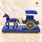 Handcrafted lapis lazuli horse-and-carriage sculpture with brass wheels and harness on a matching gemstone platform.