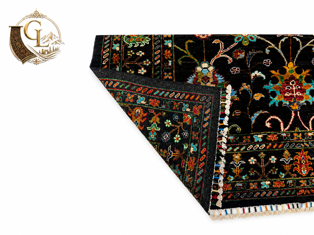 Folded corner of the Chobi Sultani Afghan carpet exposing its hand-woven cotton foundation – a mark of authentic craftsmanship, with the intricate multicolor border and hand-tied fringe visible in full detail