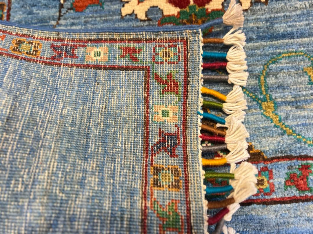 Close-up of the back of a Chobi Sultani hand-knotted Afghan carpet showing tight flat weave structure, colorful hand-tied fringe, and traditional border detail — proof of authentic hand-knotting craftsmanship from Jawzjan, Afghanistan