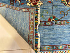 Folded corner of a Chobi Sultani Afghan carpet revealing the flat reverse weave and vibrant multi-colored hand-tied fringe — authenticating 100% hand-knotted natural wool construction, Golden Loom Afghanistan