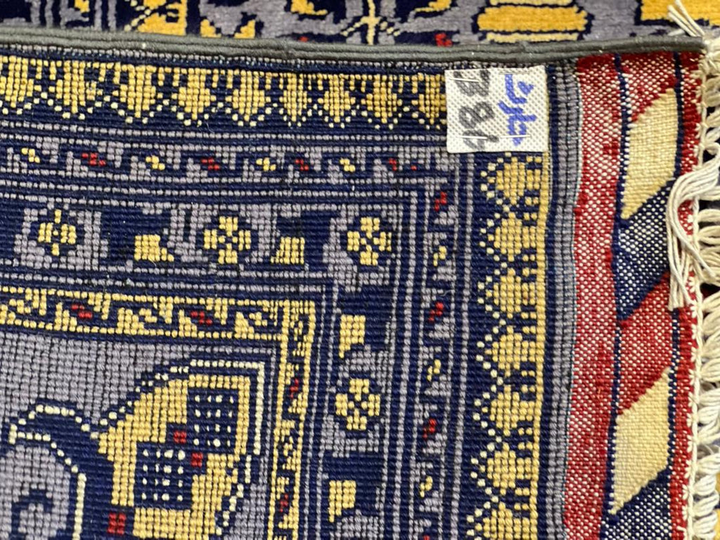 Back view of Belzhiki Afghan hand-knotted carpet showing tight knot density, natural wool fringe, and traditional ZerKhaki border detail – Golden Loom Afghanistan