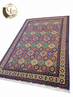 Belzhiki Afghan hand-knotted carpet angled view — multi-color tile pattern with royal blue, red and green geometric motifs, fine knotted fringe, Jawzjan Province