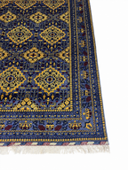 Belzhiki ZerKhaki Antique Afghan Carpet – close-up corner view showing hand-knotted blue and gold geometric pattern with natural wool fringe, by Golden Loom Afghanistan