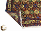 Belzhiki Afghan carpet folded to show front and back — hand-knotted tile pattern in royal blue, green, red and ivory with white knotted fringe, Jawzjan Province