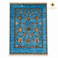 Top view of turquoise hand-knotted Afghan wool carpet with botanical motifs, colourful fringes and Golden Loom Afghanistan logo