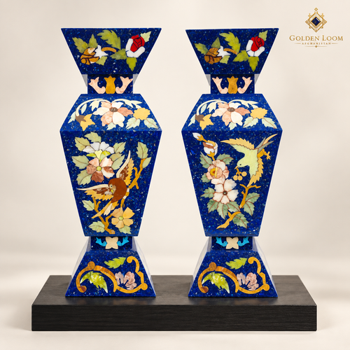 Pair of handcrafted four-sided lapis lazuli mosaic vases displayed on a black wood plinth.