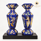 Pair of six-sided Afghan mosaic vases with bird, floral and figurative stone inlay displayed on a black wooden plinth