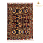 Handwoven Afghan carpet with deep burgundy field, repeating geometric medallion pattern, gold and blue floral motifs, and ivory fringe — Golden Loom Afghanistan