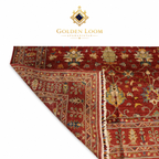 Hand-knotted Afghan Ziegler rug corner fold showing pile depth and woven back, deep red with multicolour floral motifs and ivory fringe — Golden Loom Afghanistan