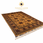 A traditional Persian-style area rug from Golden Loom, featuring a warm ochre yellow field with dark brown and black floral motifs and cream fringe, shown on a white background with the brand logo at the top.