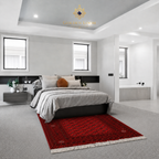 Traditional Afghan red wool rug with Bokhara medallion pattern placed at the foot of a modern bed in a contemporary bedroom, Golden Loom Afghanistan
