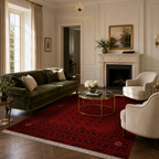 Hand-knotted Afghan red rug with traditional geometric motifs in a classic English-style living room with velvet sofa and marble fireplace, Golden Loom Afghanistan
