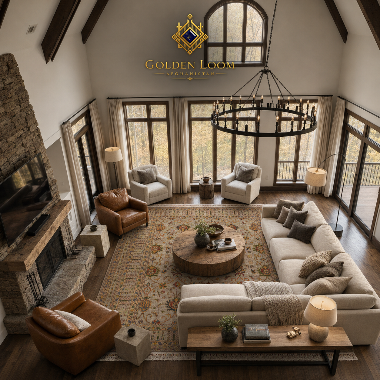 Aerial view of a handmade Afghan floral rug in a rustic mountain great room with vaulted ceilings, stone fireplace, leather armchairs, and forest views — Golden Loom Afghanistan