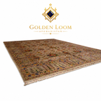 A traditional Persian-style area rug with an intricate multicolor floral and geometric pattern, shown at an angle on a white background with the Golden Loom Aghanistan brand logo above it.