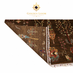 An Afghanistani area rug by Golden Loom, featuring a dark brown base with intricate multicolor floral and bird motifs, shown with one corner folded over to display both the patterned top and the reverse side on a white background.