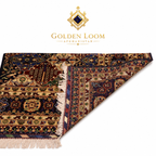 Close-up of folded Afghan handwoven carpet showing intricate floral border, dense wool pile, and ivory cotton fringe