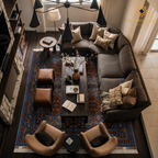 Overhead view of Afghan Mamluk carpet in royal blue and burgundy under a dark sectional sofa in a moody living room — Golden Loom Afghanistan