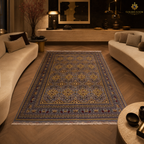 Hand-knotted Afghan carpet in grey and gold displayed between curved cream sofas in a dark luxury lounge with warm pendant lighting