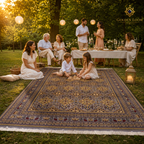 Hand-knotted Afghan carpet in grey and gold laid on grass at a golden-hour garden party with children playing and family gathered around