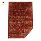 Hand-knotted Afghan Chobi rug in crimson red with all-over floral vine pattern, corner folded to show wool pile and fringe detail — Golden Loom Afghanistan
