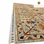 Close-up angled view of the Afghan carpet’s woven texture, decorative border and short-end fringe
