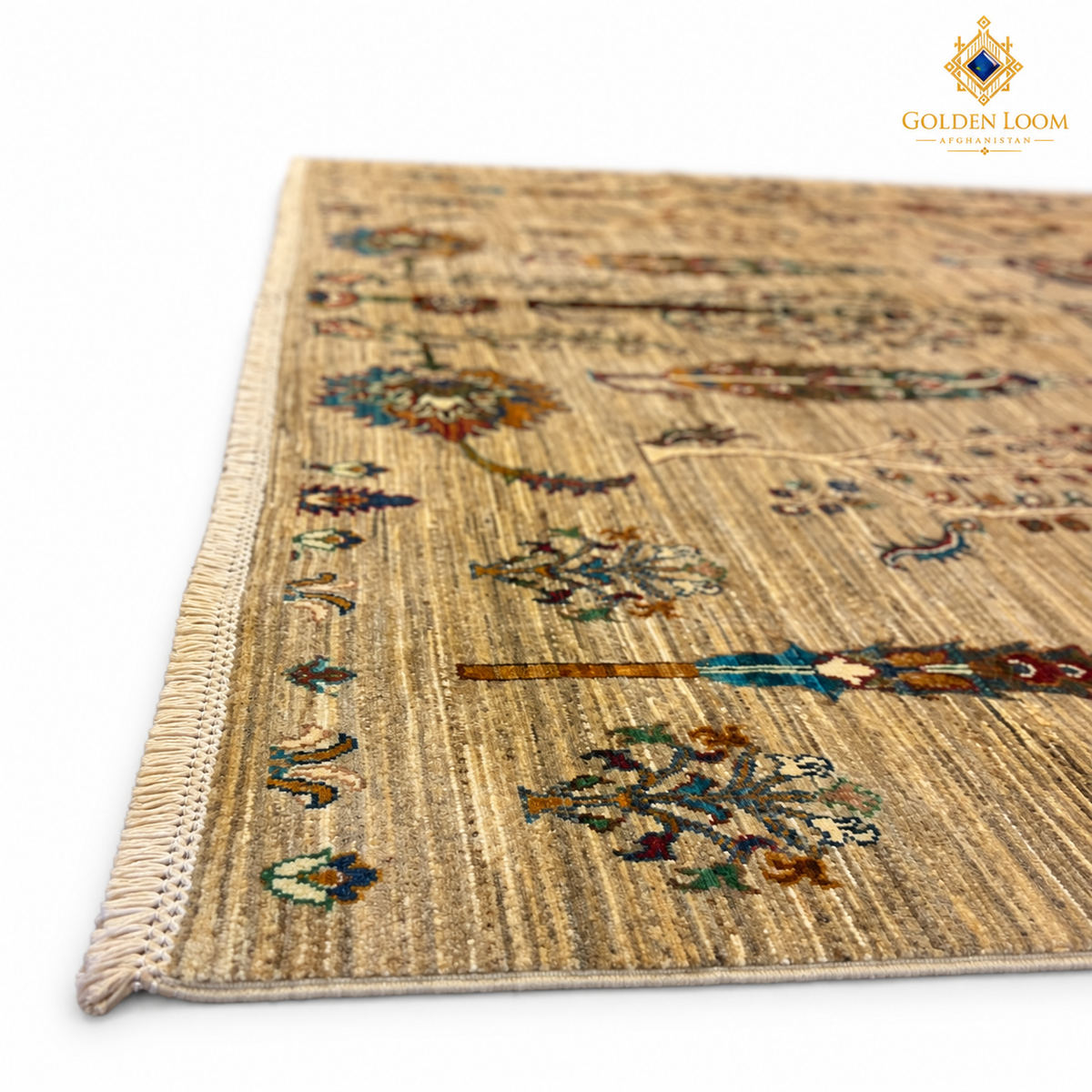Low-angle detail of a golden-beige Afghan carpet highlighting its wool texture, botanical motifs and fringe