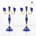 Pair of handcrafted five-arm lapis lazuli and brass candelabra on a white marble background.