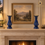 Pair of blue lapis lazuli vases arranged symmetrically on a limestone fireplace mantel beneath framed artwork.