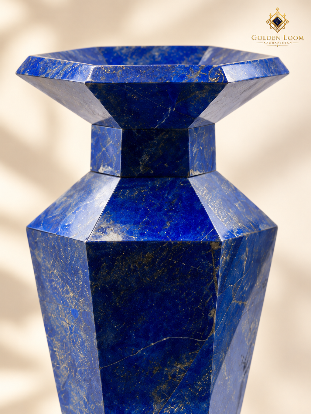 Close-up of a six-sided lapis lazuli vase showing polished panels, pyrite flecks and natural calcite veining.