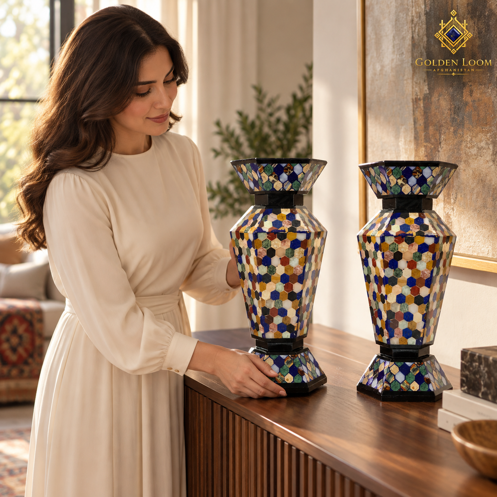 Woman carefully arranging a pair of handcrafted mosaic stone vases on a walnut console.