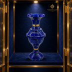 Close-up of a handcrafted lapis lazuli and brass vase displayed in a velvet-lined collector’s cabinet.