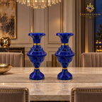 Imperial lapis lazuli vase pair arranged on a marble dining table beneath a contemporary chandelier.