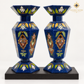 Pair of handcrafted six-sided mosaic vases with lapis lazuli chips and colorful semi-precious stone inlay on a black wooden plinth
