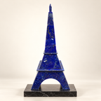 Handcrafted lapis lazuli Eiffel Tower sculpture displayed on a black marble plinth against an ivory background.