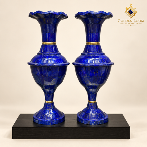 Matched pair of handcrafted lapis lazuli and brass vases displayed on a black wood plinth.