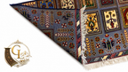 Belzhiki & Regional Mirror Design Afghan carpet – corner folded back on white background revealing flat-woven reverse side with arrow and floral motifs, showing pile depth, knot construction and hand-tied ivory fringe, slate-blue field with botanical panels visible on front face, 100% Turkman wool, hand-knotted in Qarqin, Jawzjan, Afghanistan, Golden Loom