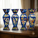 Set of four hand-painted Afghan lapis lazuli vases with floral and bird stone inlay motifs in blue, green, yellow and white, displayed on a wooden sideboard in a warm home interior — Golden Loom Afghanistan