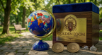 Royal Lapis Lazuli Globe displayed beside a Golden Loom Afghanistan luxury wooden gift box with gold plaque, branded coins, and glasses on a park table