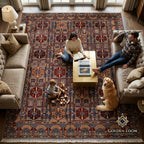 Large Afghan handmade carpet in rich red and blue tones with geometric motifs shown in a cozy family living room with a golden retriever — Golden Loom Afghanistan