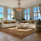 Handwoven Afghan carpet with all-over floral pattern styled in a bright Scandinavian living room under a crystal chandelier