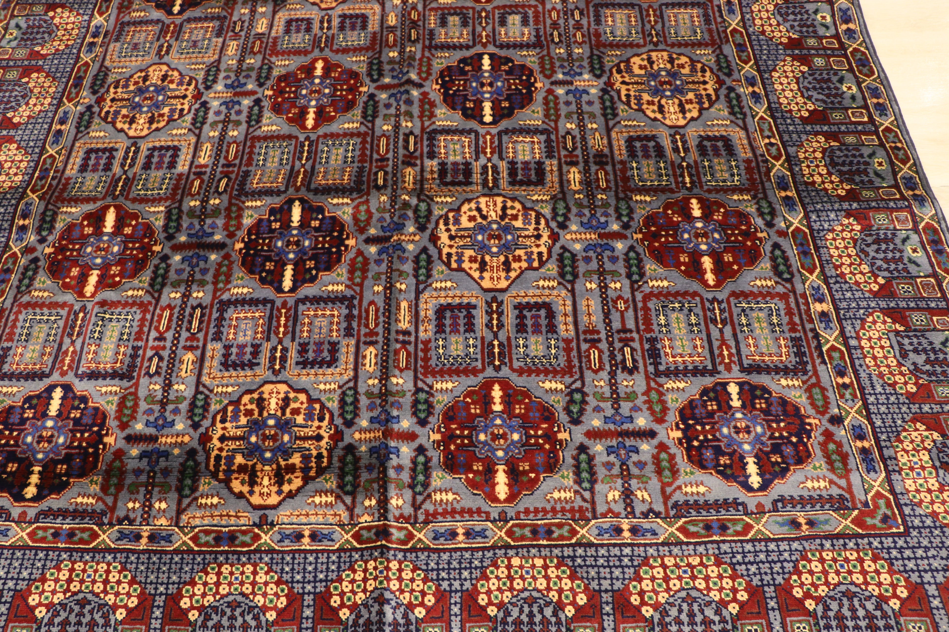 Overhead view of a high-quality Afghan  rug featuring a symmetrical blue, red, and cream geometric pattern and ornate central motifs