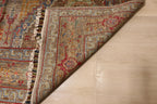 Detail of handwoven Afghan carpet corner folded back revealing dense knotted reverse with intricate border pattern in red, blue, and taupe