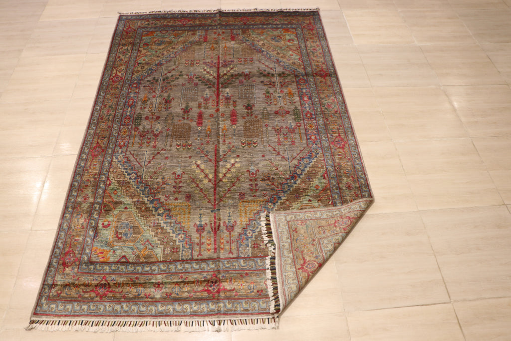 Full view of handwoven Afghan carpet with grey-taupe field, all-over botanical motifs, and multicolor geometric border, corner folded to show reverse