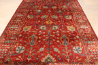 Low-angle view of Afghan hand-knotted red Chobi carpet showing full floral field pattern, geometric border, and natural wool texture on light floor — Golden Loom Afghanistan