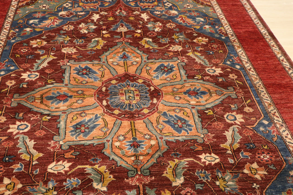 Close-up of Chobi Kashan hand-knotted Afghan carpet showing central star medallion in peach and blue tones on deep red wool ground
