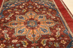 Close-up of Chobi Kashan hand-knotted Afghan carpet showing central star medallion in peach and blue tones on deep red wool ground