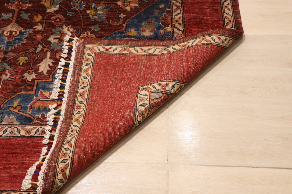 Folded corner of Chobi Kashan Afghan carpet revealing hand-knotted wool backing with ivory and red border detail