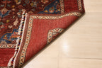 Folded corner of Chobi Kashan Afghan carpet revealing hand-knotted wool backing with ivory and red border detail