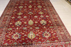 Afghan hand-knotted wool rug with all-over red Ziegler floral pattern photographed on workshop floor, showing natural dye Color and fine knotting detail